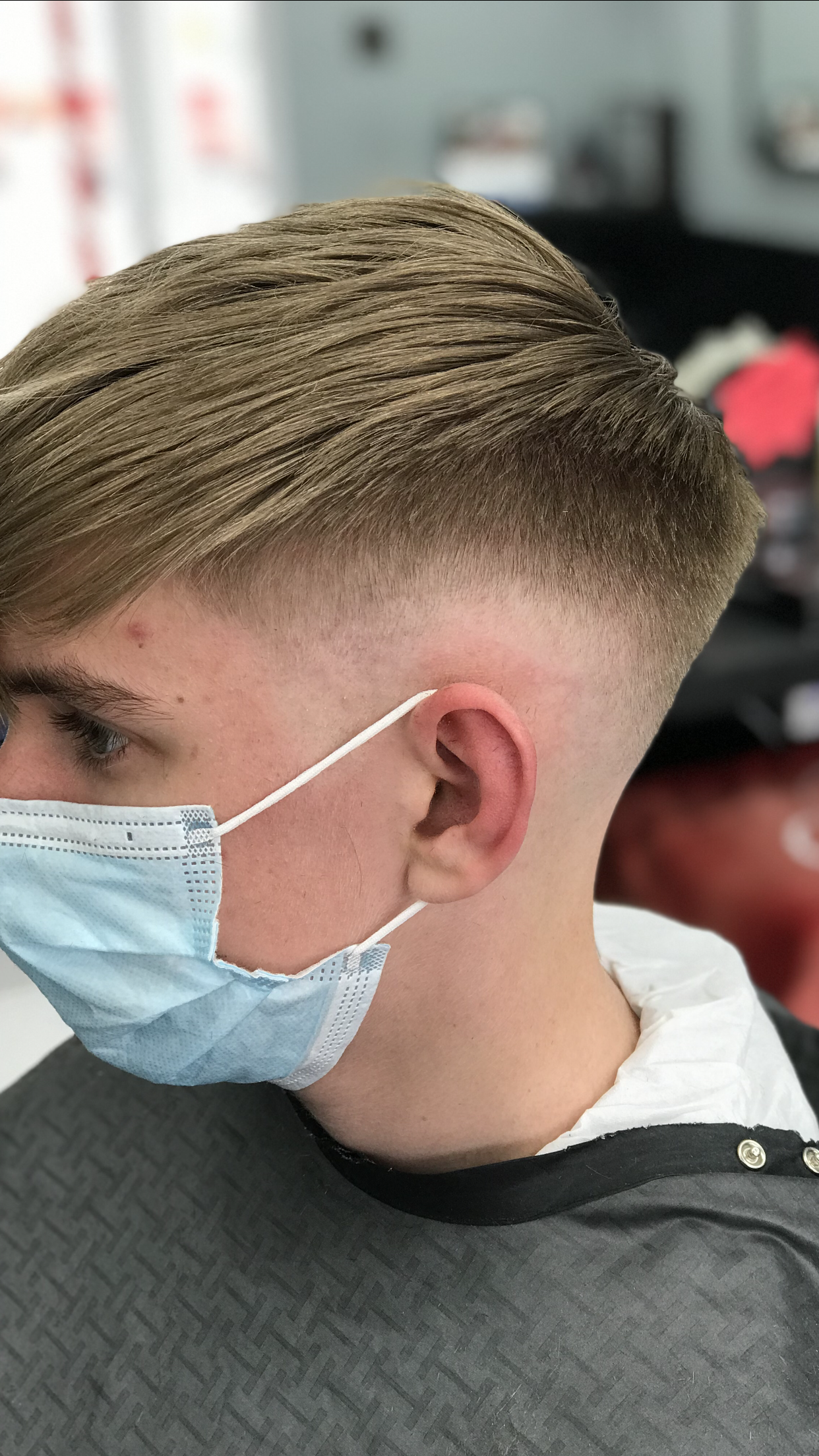 Skin fade with a textured top, client in profile